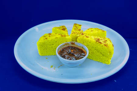 Gujarati famous dhokla peaces with garlic red chutney, Isolated with Blue Color Background
