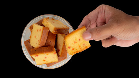 Picked up a piece of cake from the cake bowl. Isolated On Black Backgroundの写真素材