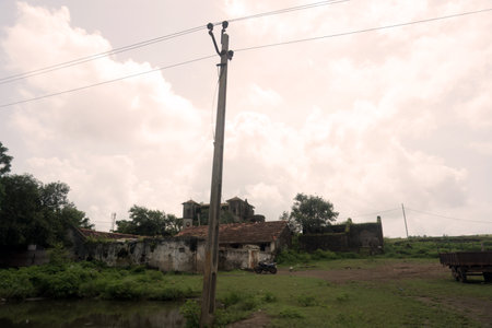 The house and the power pole are prominently placed within this wide landscape, which stretches out in all directions, offering an unobstructed view of the horizon.の写真素材