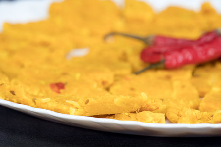 Very Close-Up and Selective Focus Of Gujarati Kathiyawadi Spicy Dhokali Sabji On White Plate, Red...