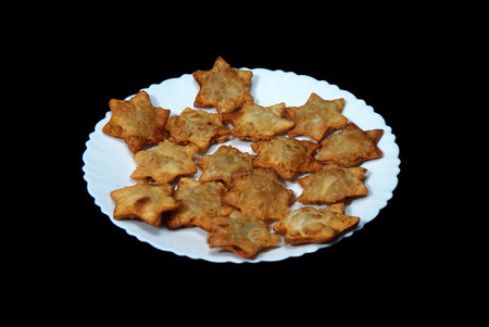 Aloo Puff Pastry served on a plate with tomato sauce, set against a black background.