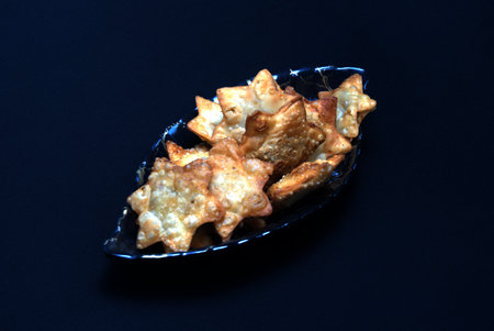 A glass bowl filled with deliciously fried chicken wings, elegantly presented with a vibrant tomato sauce on the side.の写真素材
