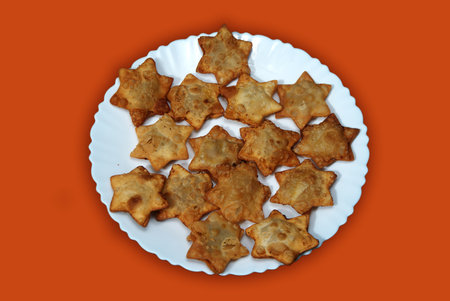 Aloo Puff Pastry with a side of tomato sauce, elegantly arranged on a plate with a red background.