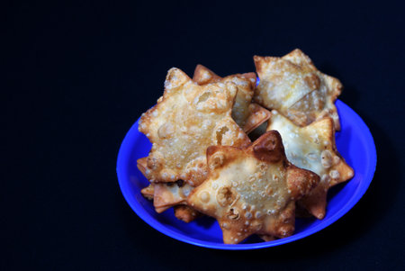 A blue plate holds Aloo Puff Pastry served with a side of tomato sauce.の写真素材