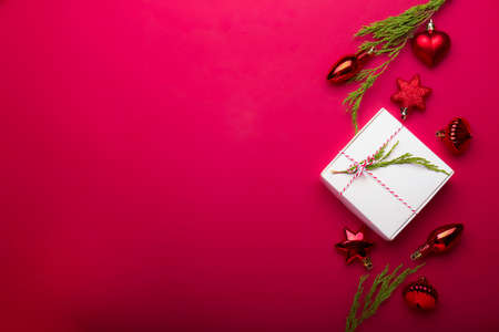 Christmas composition. Christmas red decorations, fir tree branches on red background. Flat lay, top view, copy spaceの写真素材