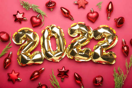 Concept 2022 New Year. Gold inflatable balls on a red background.の写真素材