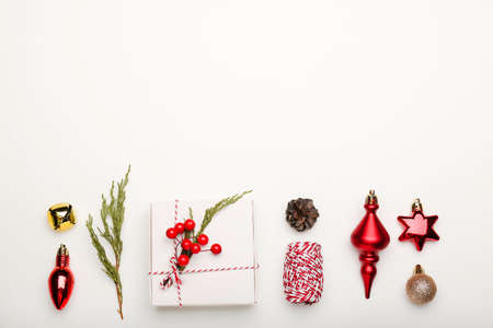 Christmas composition. Gifts, fir tree branches, red decorations on white background. Flat lay, top view, copy spaceの写真素材