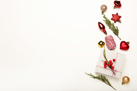 Christmas or Happy New Year composition. Fir tree branches, golden and red decorations on white background.の写真素材