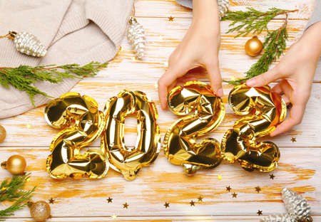 2022 balloons on a light wooden background with hands. New Year conceptの写真素材