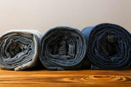 rolled blue jeans of different shades on wooden backgroundの写真素材