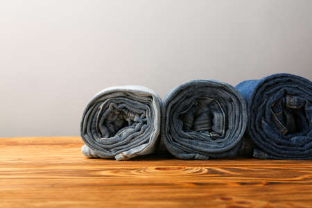 olled blue jeans of different shades on wooden backgroundの写真素材
