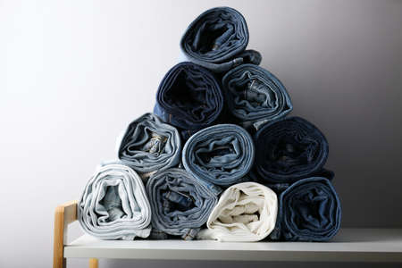 folded jeans stacked on a shelfの写真素材