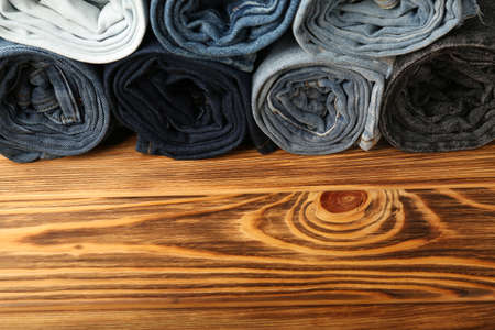 Rolled blue jeans on wooden background .Place for textの写真素材