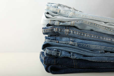 stack of blue jeans on white background. Jeans collection