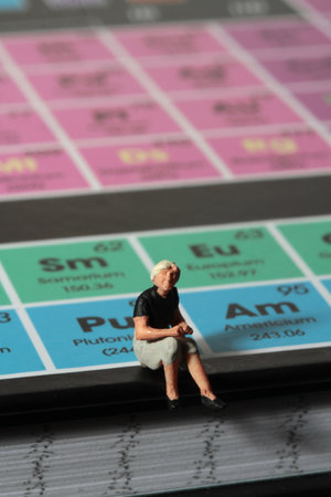 miniature people sitting on the periodic table of chemical elements, business conceptの写真素材