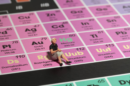 Miniature people sitting on periodic table of chemical elements. Chemistry concept. Selective focus.の写真素材