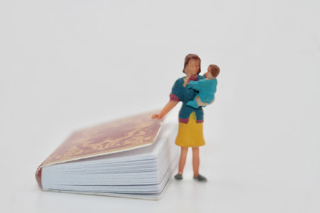 Miniature people : Mother and baby holding book on white background.の写真素材