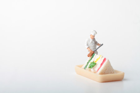 Chef decorating a sandwich on white background.の写真素材