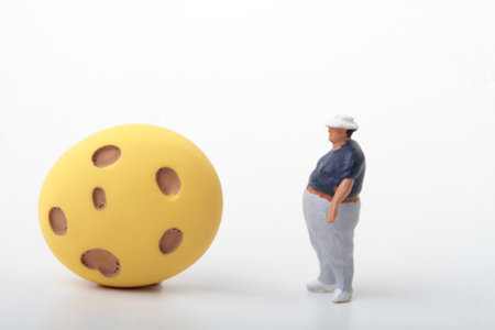 Miniature people : Old man with cheese ball on white backgroundの写真素材