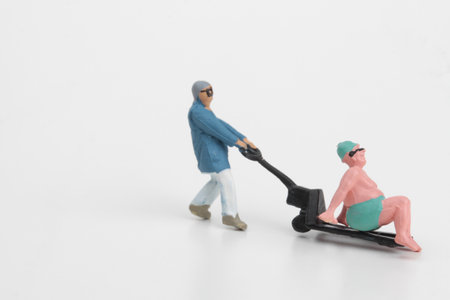 Miniature people : Worker pushing forklift on white background with a man taking a sunbathの写真素材