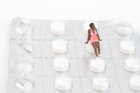 Miniature people : Young woman sitting on a blister pack of pillsの写真素材