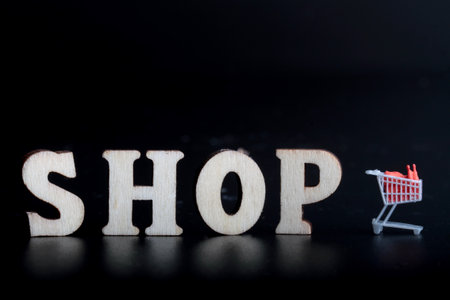 Shopping word made with wooden letters on black background, shopping conceptの写真素材