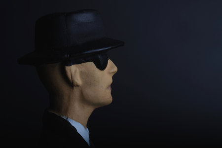 man in black hat and tie on black background with copy space.の写真素材