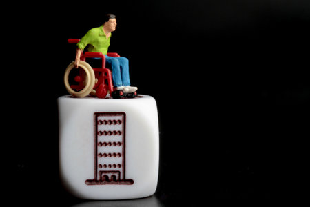 Miniature people : handicapped man with wheelchair and building symbol on a black backgroundの写真素材