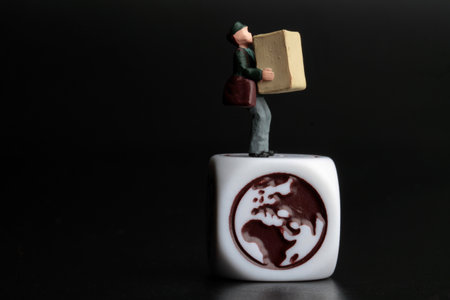 miniature people with cardboard box on the white cube with world symbol over black backgroundの写真素材