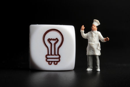 Miniature people : chef with light bulb on a black background.の写真素材