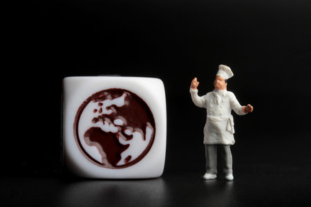 Miniature people : Chef and globe symbol on a black background.の写真素材