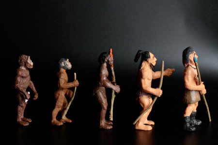 Wooden figurines of the ancient people on a black background. Human evolution conceptの写真素材