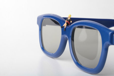 Miniature people : worker in sunglasses on white background with copy space.