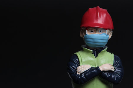 A closeup shot of a plasticine construction worker wearing a mask