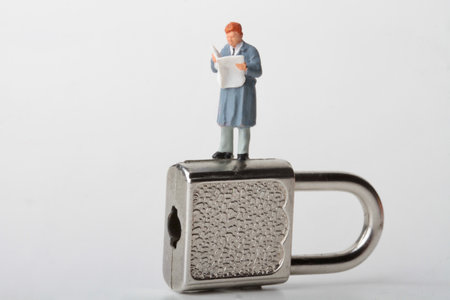 Miniature people: Businessman standing on a padlock and reading a newspaper