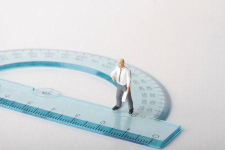Miniature people : Businessman standing on the ruler. Image use for business concept.の写真素材