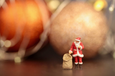 Santa Claus with sack of gifts and christmas balls on bokeh background