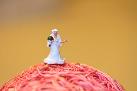 Miniature people : bride figurine standing on the top of a cakeの写真素材