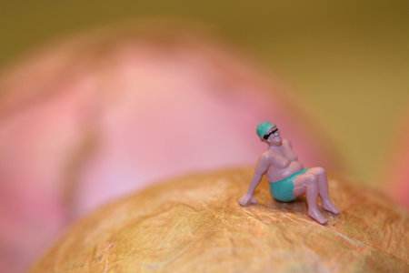 Miniature people: swimmer sitting on a big sphere.の写真素材