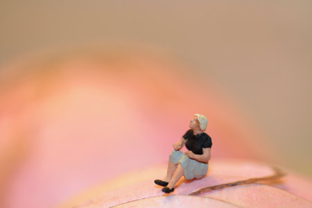 Miniature people : lonely woman sitting on the lotus flower.の写真素材