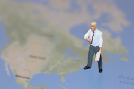 Miniature people : Businessman standing on the map of the worldの写真素材