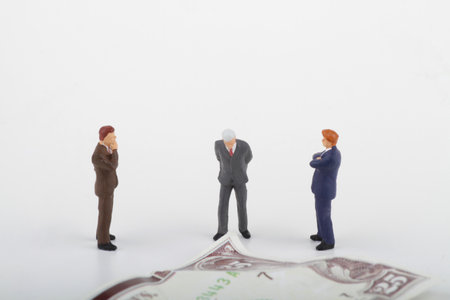miniature business people standing on a money background with copy space.の写真素材