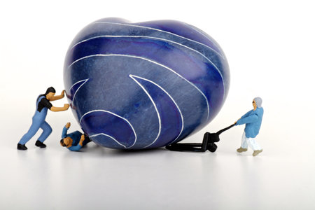 Miniature people : Couple on a blue heart with white backgroundの写真素材