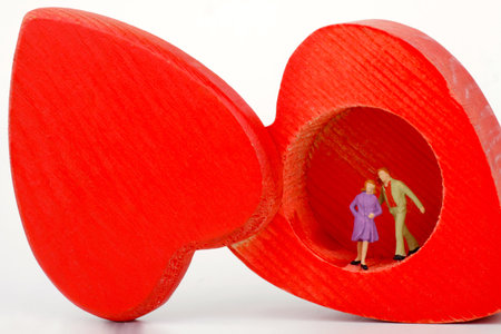 Miniature people : Couple in love with red heart shape on white backgroundの写真素材