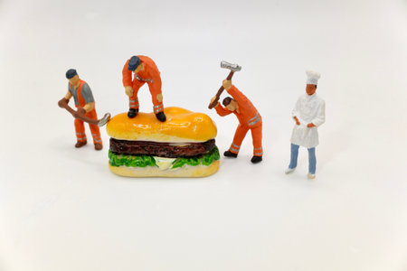miniature people worker with hamburger on white background, food conceptの写真素材