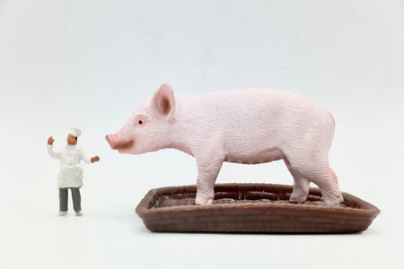 miniature figurine of a cook with a pig on a trayの写真素材