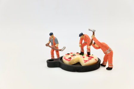 Miniature people : miniature figurines of men at work with a huge pizza on a trayの写真素材