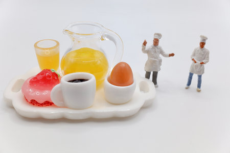 miniature figurines of cooks with a breakfast served on a trayの写真素材