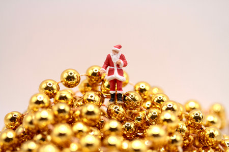 Miniature people : Santa Claus with golden christmas balls background.の写真素材