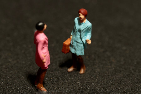 two miniatures of gossiping womenの写真素材